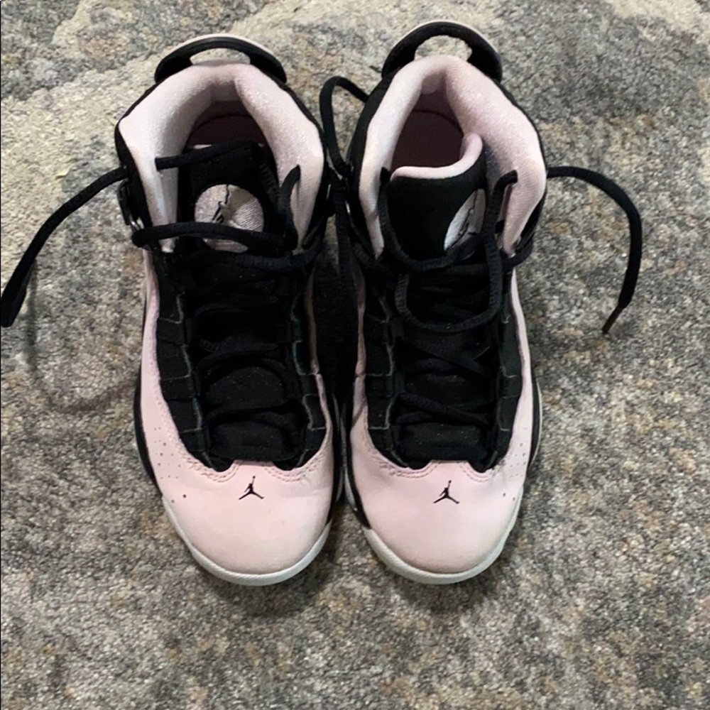 Little girls pink and black Jordan sneakers.